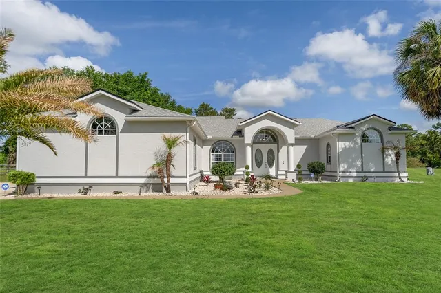 a view of a patio with table and chairs with plants and garden