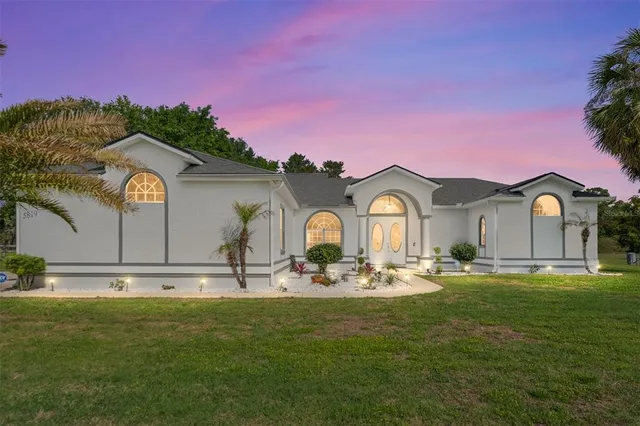 a view of a house with backyard and sitting area