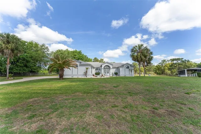 a front view of house with yard and trees