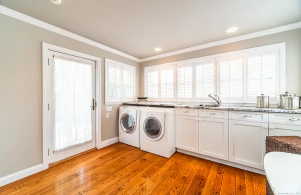 a view of a kitchen with a sink dishwasher and wooden floor