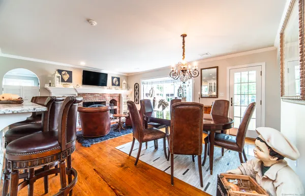 a dining room with furniture a chandelier and wooden floor