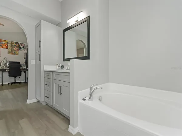 a bathroom with a bathtub sink and mirror