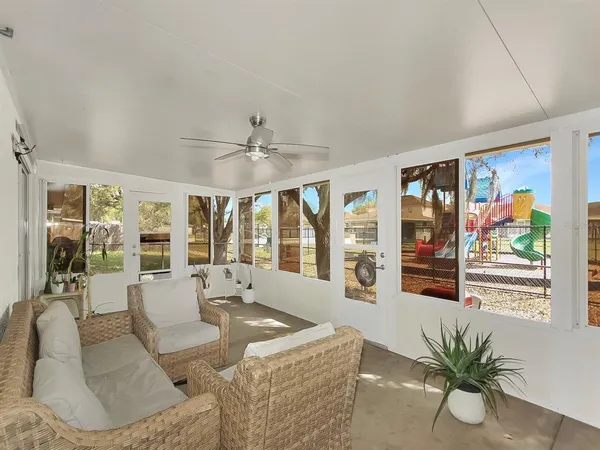 a living room with furniture and large windows