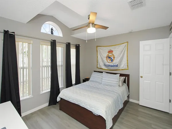 a bedroom with a large bed and a chandelier