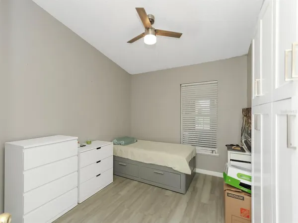 a bedroom with a bed and a ceiling fan
