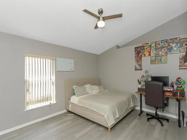 a white bed sitting in a bedroom next to a window