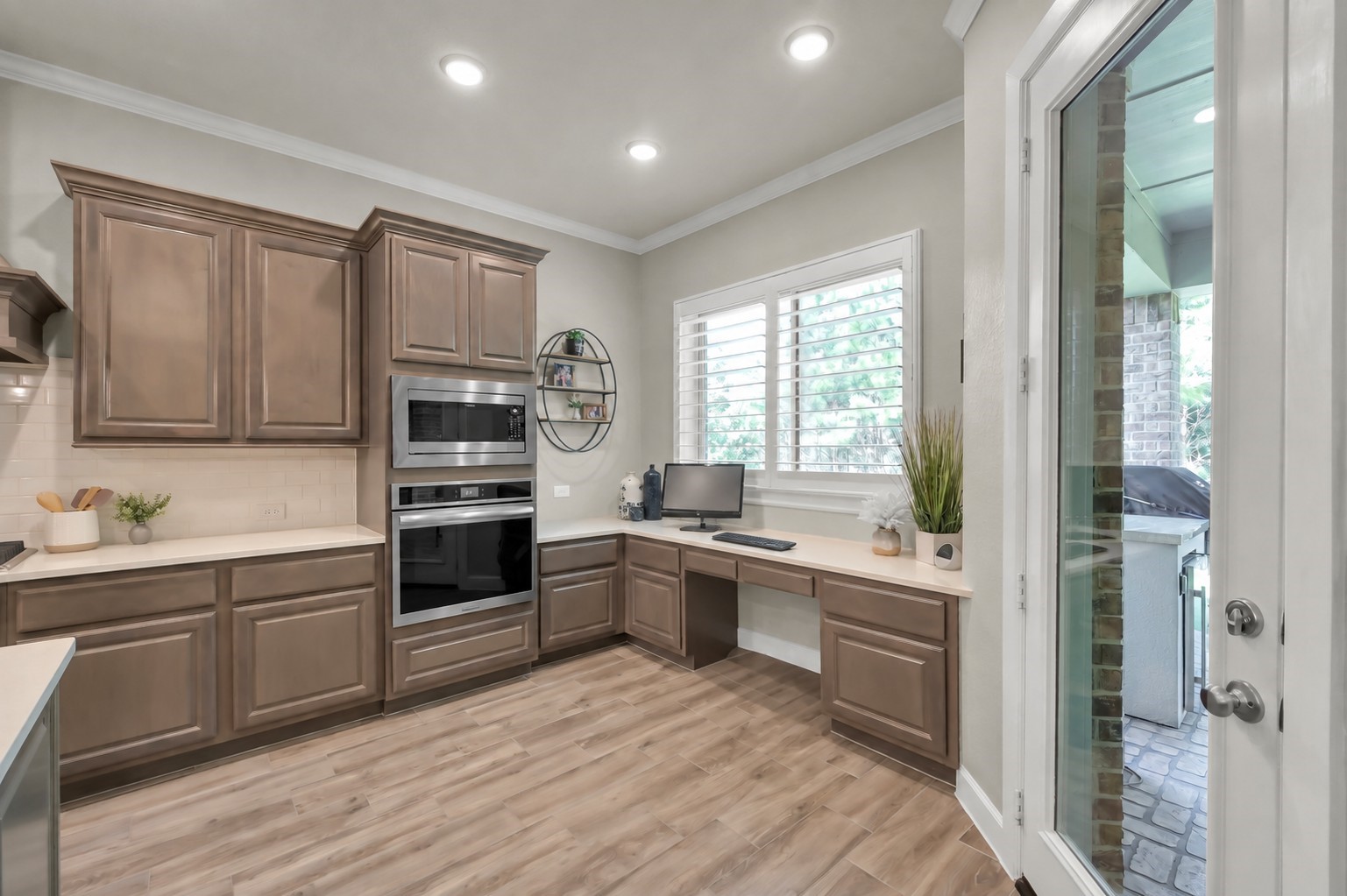 334 Torrey Bloom Loop Conroe, TX 77304 - Photo 20 of 47 Virtually removed chair at desk. Thoughtfully designed kitchen workspace with built-in desk, ample cabinetry, and convenient access to the covered patio—perfect for work or everyday organization.