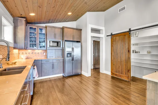 a kitchen with stainless steel appliances granite countertop a refrigerator and a sink