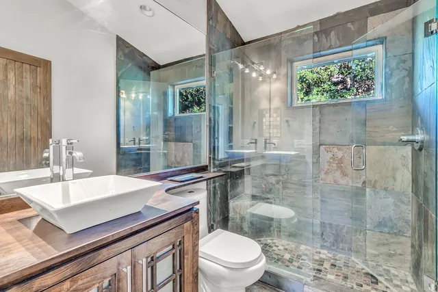 a bathroom with a sink a toilet and shower