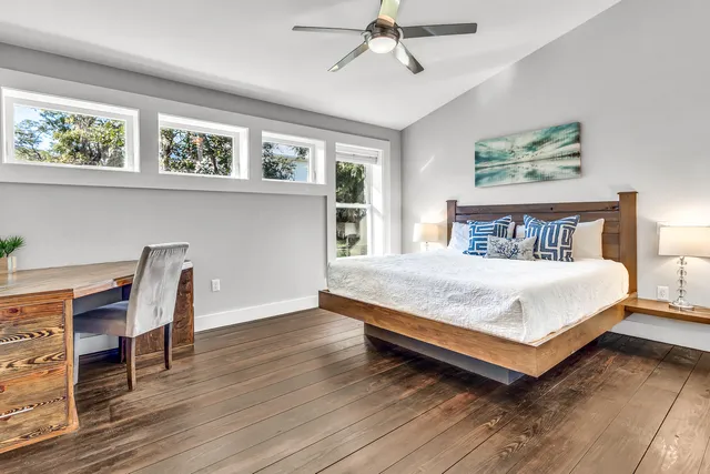 a bedroom with a bed a table and painting on the wall