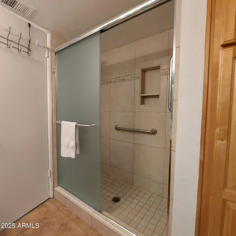 a bedroom with a large bed and a flat tv screen on dresser