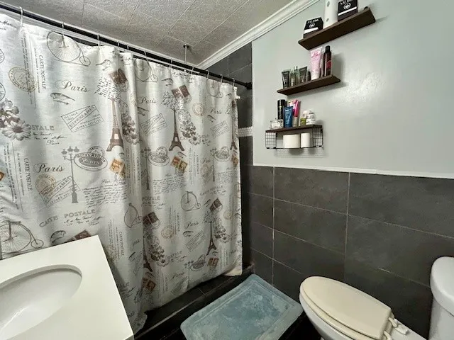 a bathroom with a sink a toilet and shower curtain