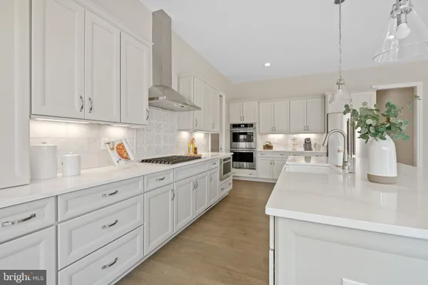 a large kitchen with kitchen island white cabinets and white appliances