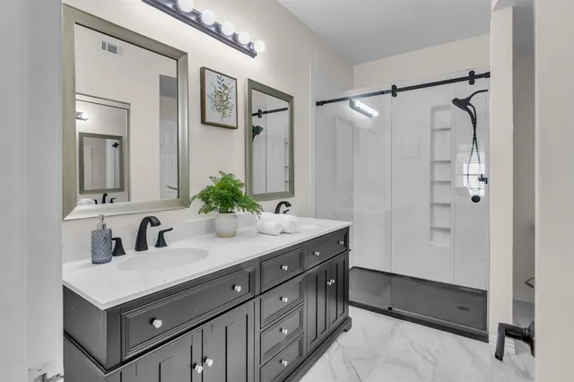 a bathroom with a double vanity sink mirror and shower