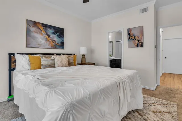 a bedroom with a bed and painting on the wall