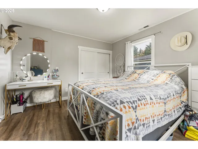 a bedroom with a bed a dresser and potted plants