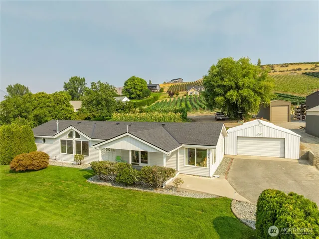 a front view of a house with a yard and potted plants