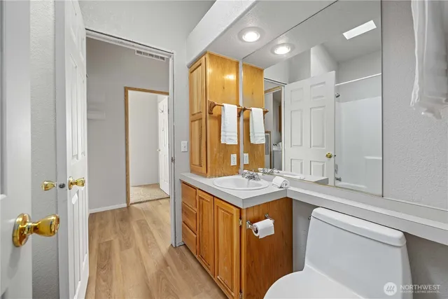 a bathroom with a granite countertop sink toilet and shower