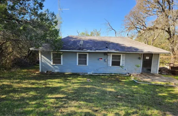 a view of a yard in front of a house with large tree