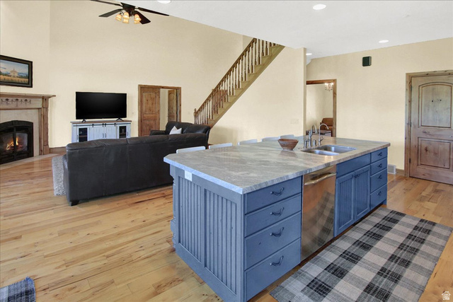 667 Hardscrabble Road Morgan, UT 84050 - Photo 51 of 51 Kitchen featuring open floor plan, an island with sink, light wood-style flooring, a fireplace, and stainless steel dishwasher