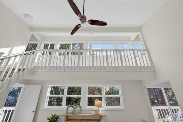 a open kitchen with granite countertop a refrigerator a sink dishwasher and white cabinets with wooden floor