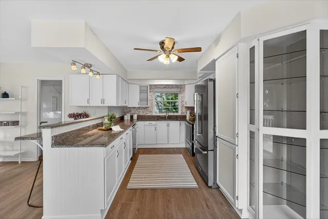 a kitchen with stainless steel appliances kitchen island granite countertop a table and chairs in it