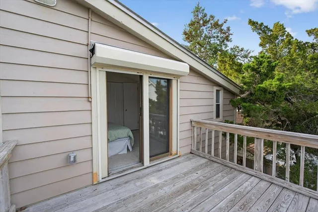 a view of a house with a small yard and large trees