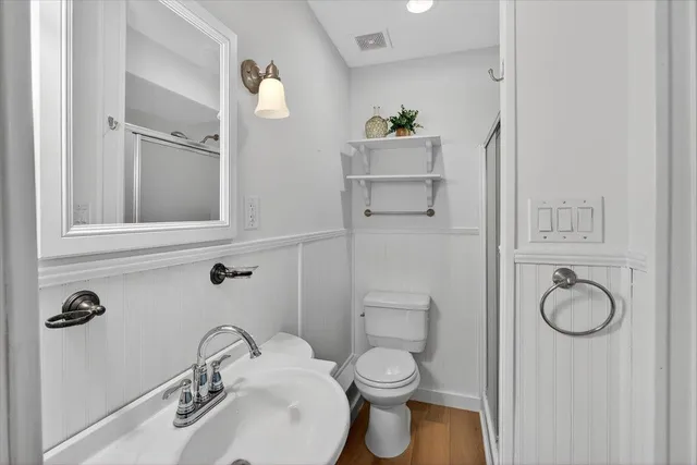 a view of a brick house with a large window and wooden fence