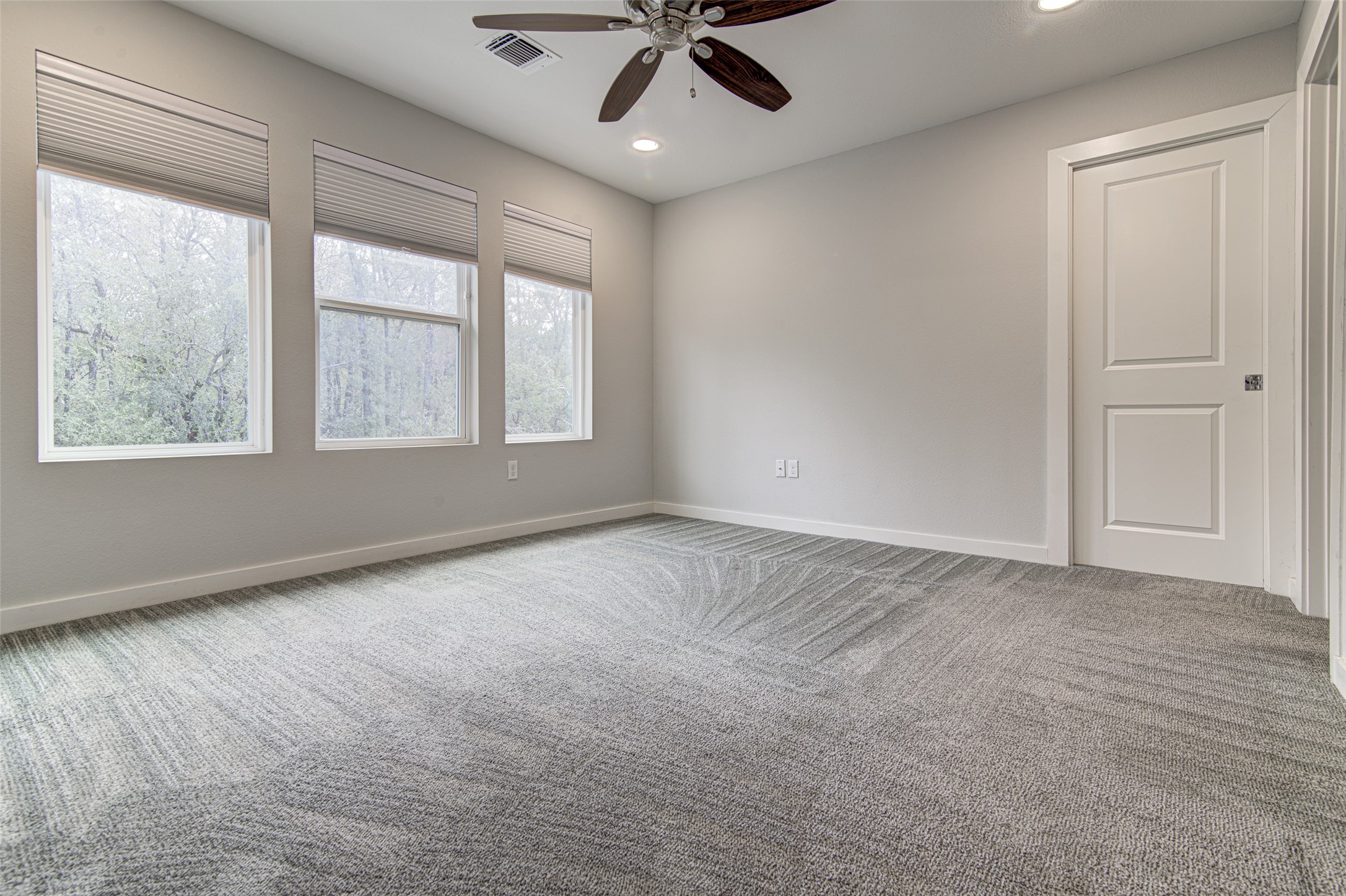 1904 Bunche Road, Unit B Austin, TX 78721 - Photo 11 of 29 Primary bedroom with three large windows overlooking the backyard and mature trees.