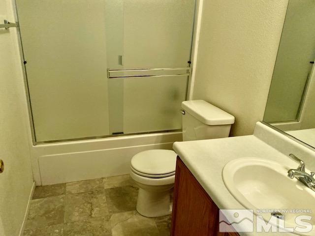 7622 Corso Street Reno, NV 89506 - Photo 14 of 19 a bathroom with a granite countertop toilet and a sink