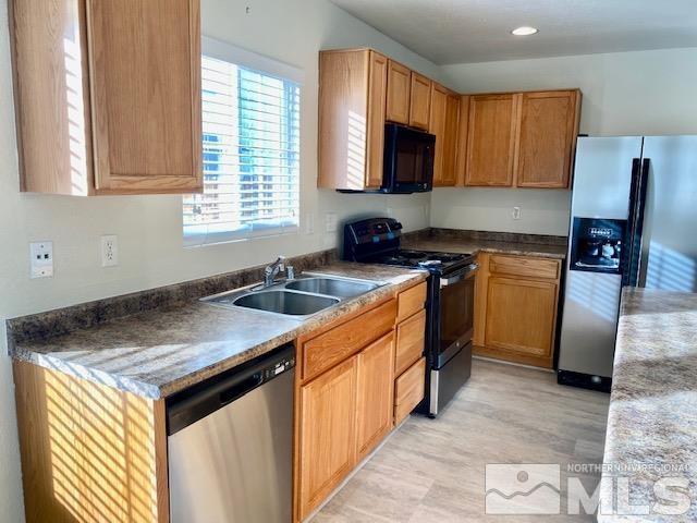 7622 Corso Street Reno, NV 89506 - Photo 6 of 19 a kitchen with granite countertop a sink stove and cabinets