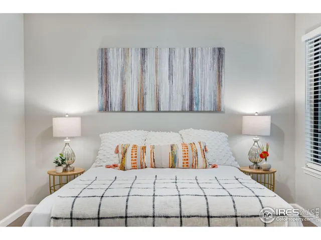 a bedroom with a bed and a lamp on dresser