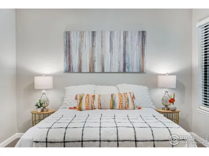 a bedroom with a bed and a lamp on dresser