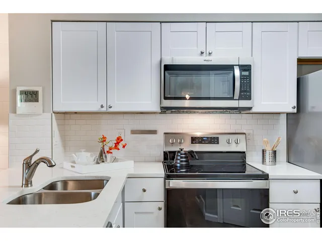 a kitchen with stainless steel appliances granite countertop a sink a stove a microwave and cabinets