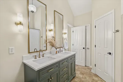 a bathroom with a sink a mirror a vanity and a shower