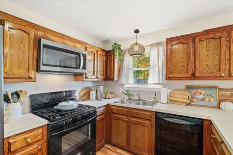 a kitchen with stainless steel appliances granite countertop a stove a sink and a microwave