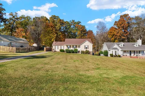 a front view of a house with a yard and trees