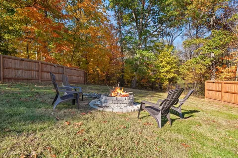 a view of a backyard with chairs potted plants and wooden fence