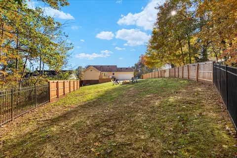 a view of a yard with wooden fence