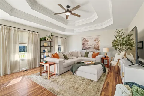 a living room with furniture a flat screen tv and a window