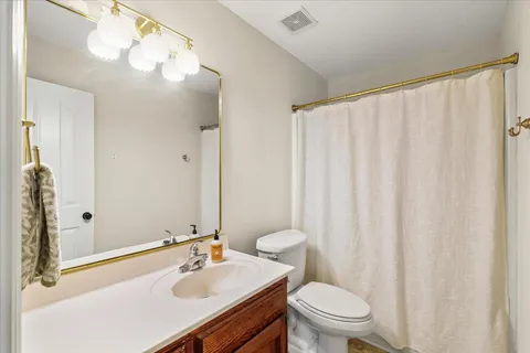 a bathroom with a sink a toilet and shower curtain