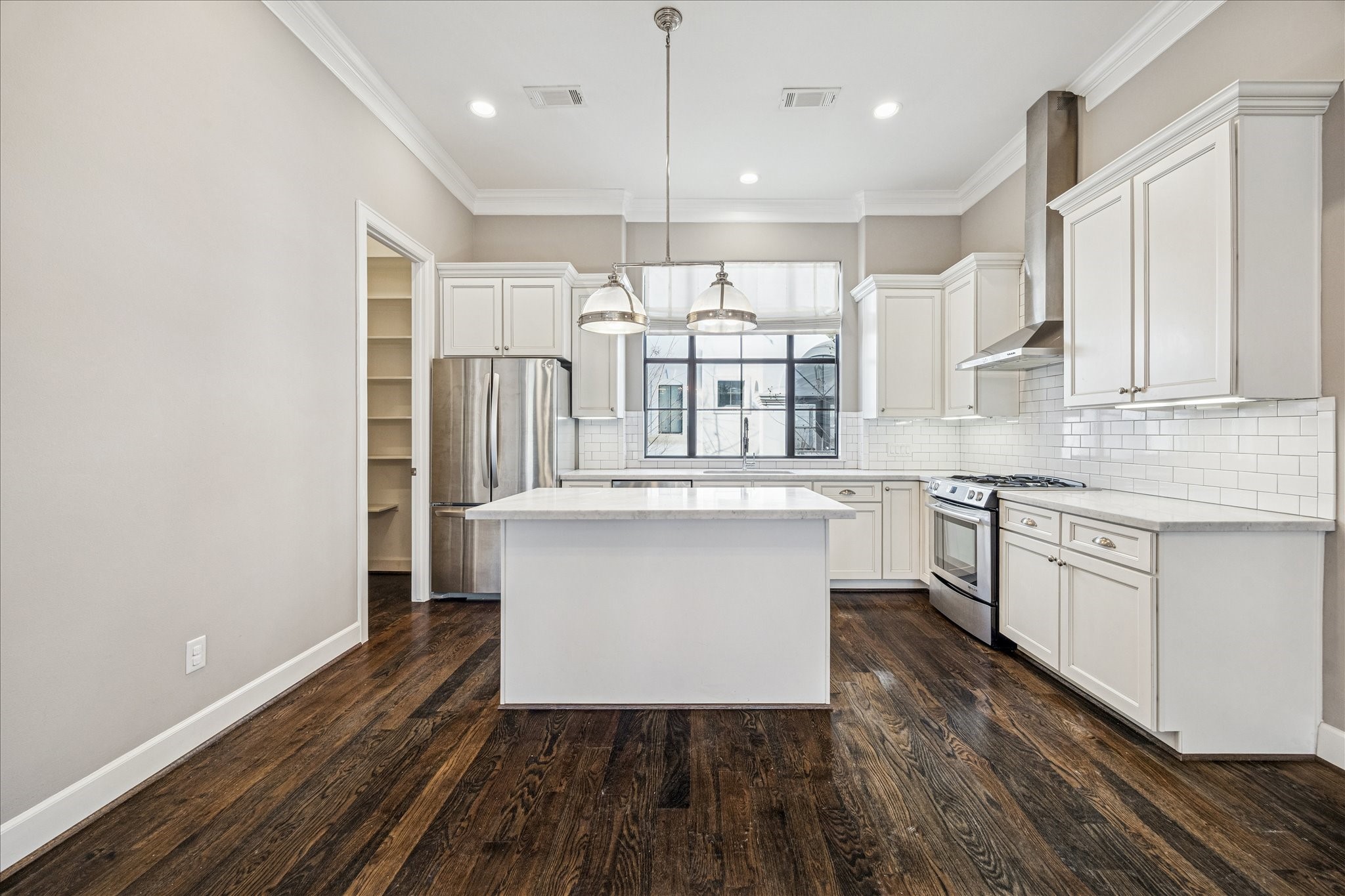2210 Converse Street Houston, TX 77006 - Photo 9 of 35 a large kitchen with stainless steel appliances a large counter top a sink a refrigerator and a window