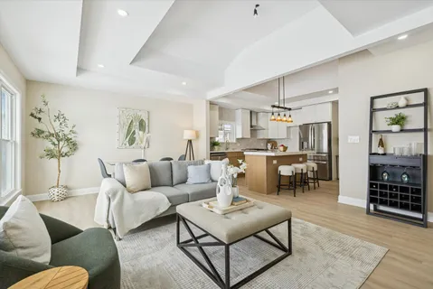 a living room with furniture kitchen view and a table