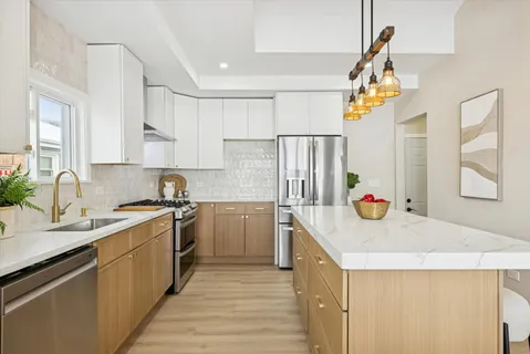 a kitchen with kitchen island a sink a stove and refrigerator