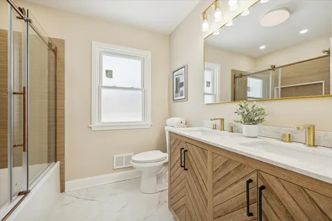 a bathroom with a sink a toilet and a mirror