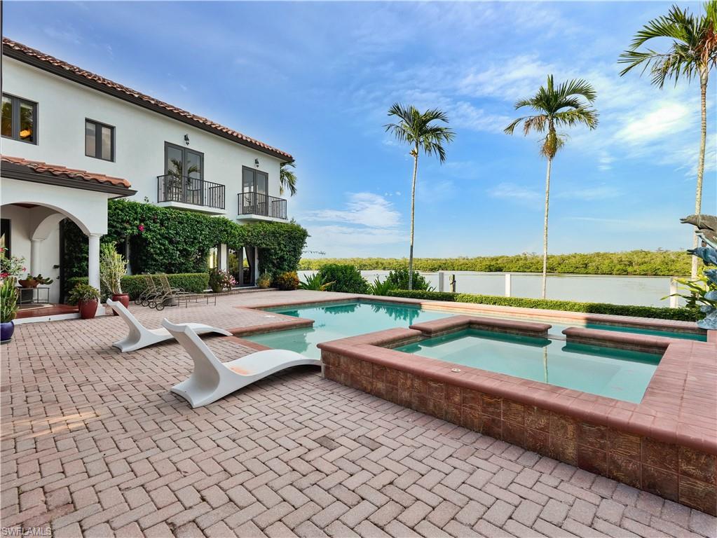 2535 Tarpon Road Naples, FL 34102 - Photo 50 of 50 Waterfront property featuring a Mediterranean-inspired exterior with multiple red tile roofs, a circular turret, arched entryways, and a paver driveway
