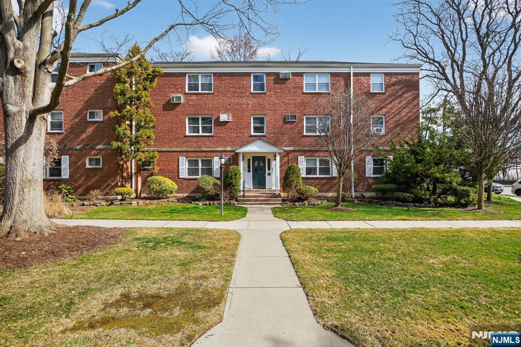 a front view of a residential apartment building with yard