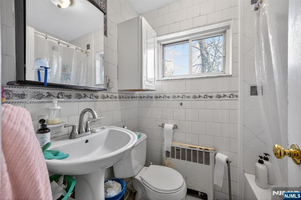 243 Johnson Avenue, Unit L4 Hackensack, NJ 07601 - Photo 17 of 25 a bathroom with a sink a toilet and mirror