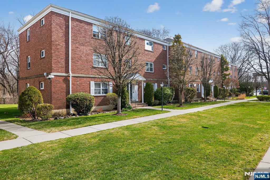 243 Johnson Avenue, Unit L4 Hackensack, NJ 07601 - Photo 24 of 25 a front view of a building with garden and trees