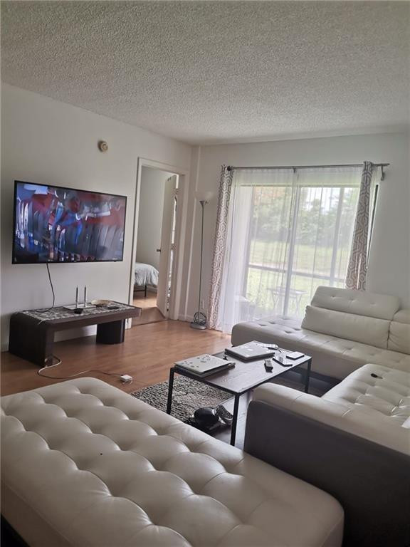 9449 Boca Cove Circle, Unit 908 Boca Raton, FL 33428 - Photo 2 of 12 a living room with furniture and a flat screen tv